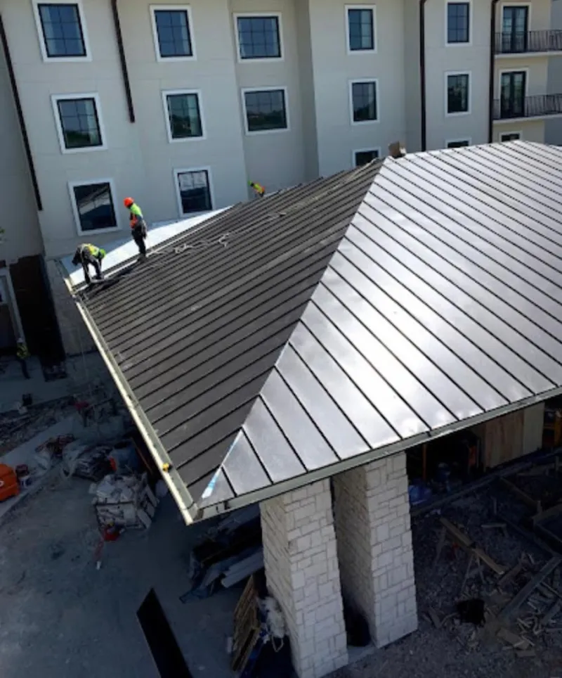 Crew installing standing seam metal roof panels on a commercial project in Truckee